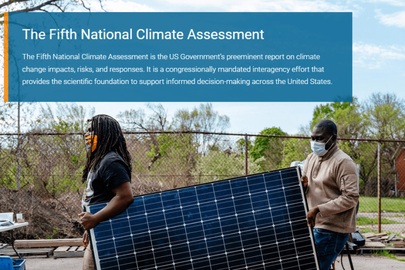 Background image shows two Black men in masks carrying a solar panel. A blue text box with information about the Fifth National Climate Assessment hovers over the top of the photo. 