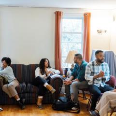 Switzer Fellows sit on couches and chairs talking in pairs at the 2023 Fall Retreat.