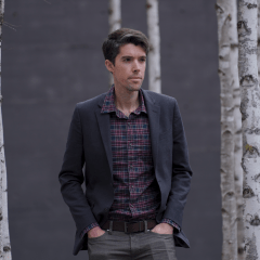 Daniel Swain stands in front of birch trees.
