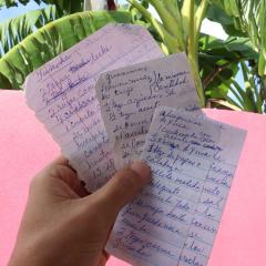 Luis holds pages from the notebook of traditional Puerto Rican recipes his grandmother shared with him.