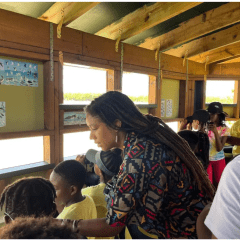 Olivia Walton stands with a group of students in a bird watching blind.