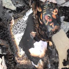 Burned composition notebooks and research papers sit in a pile of ashes from the fire.
