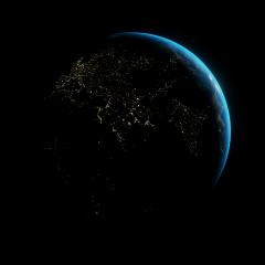 A view of the earth from space at night above Africa, Europe and India, with a blue glow on the right side of the globe. 