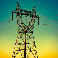 A power line against a yellow and blue sunset sky