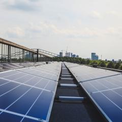 Rooftop solar panels with a city skyline in the distance