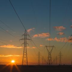 Power lines with a sunset in the background