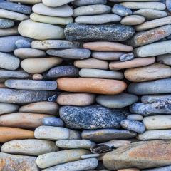 a wall of naturally colorful weathered stones stacked on top of each other