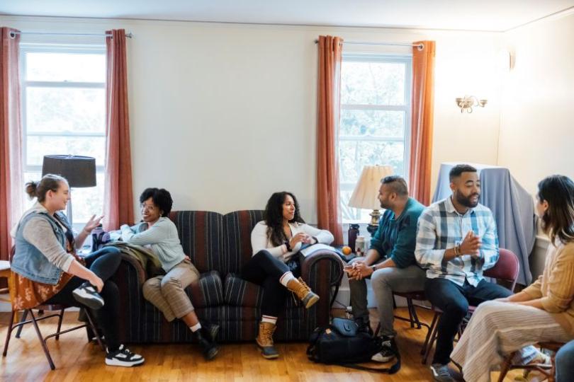 Switzer Fellows sit on couches and chairs talking in pairs at the 2023 Fall Retreat.