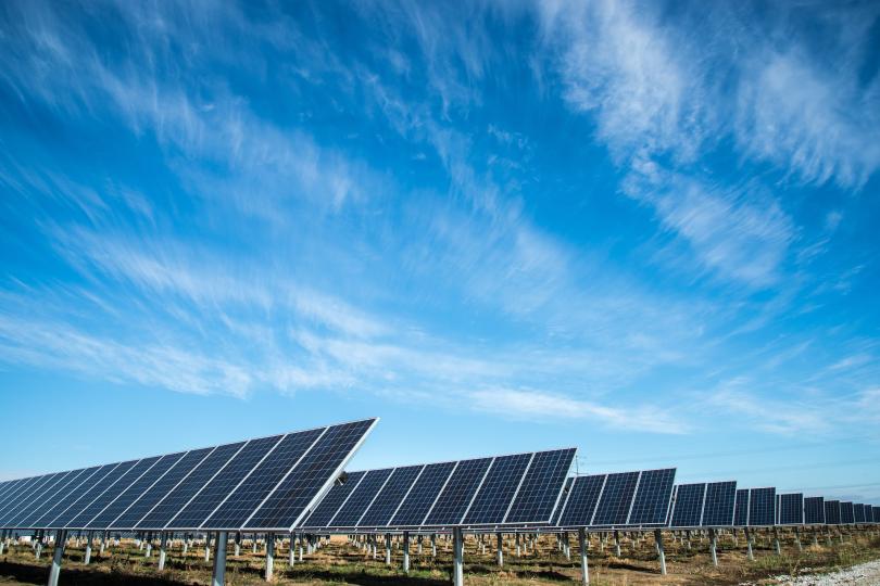 Solar panels and blue sky with wispy clouds