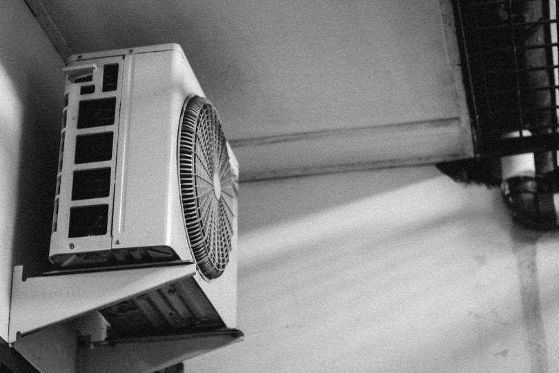 A black and white photo of a wall mounted air conditioner.