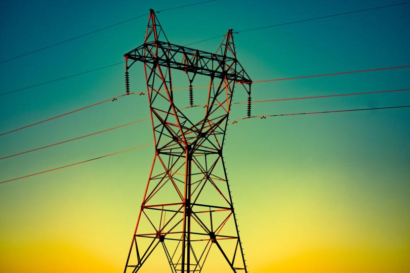 A power line against a yellow and blue sunset sky