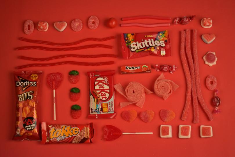 Red candy and processed snacks are artfully arranged in a rectangle.