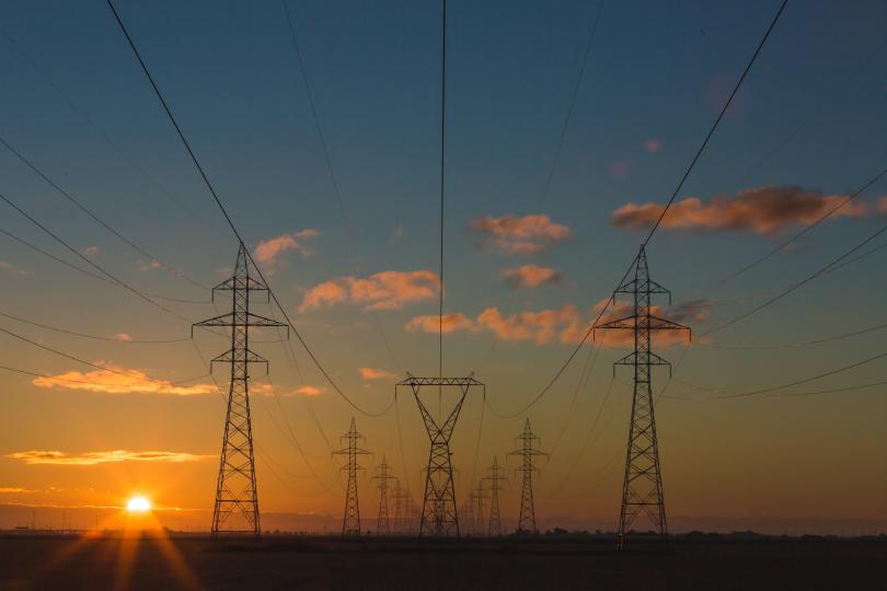 Power lines with a sunset in the background