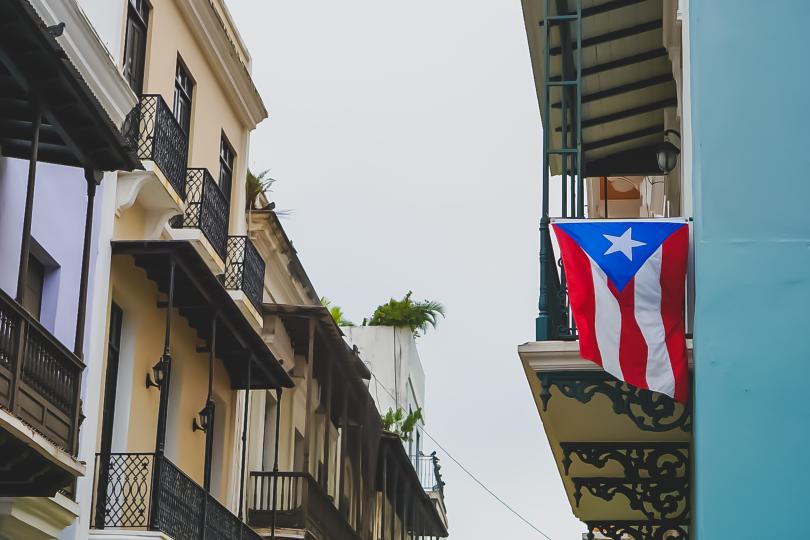 A Puerto Rican flag hangs from an apartment balcony