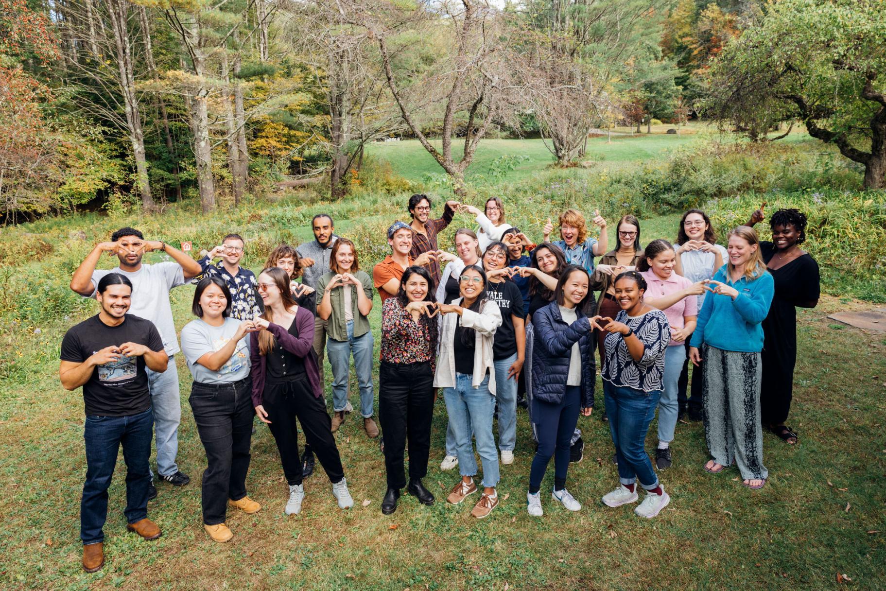 Switzer Fellows and staff make hearts with their hands in a group photo at the 2024 Fall Retreat.