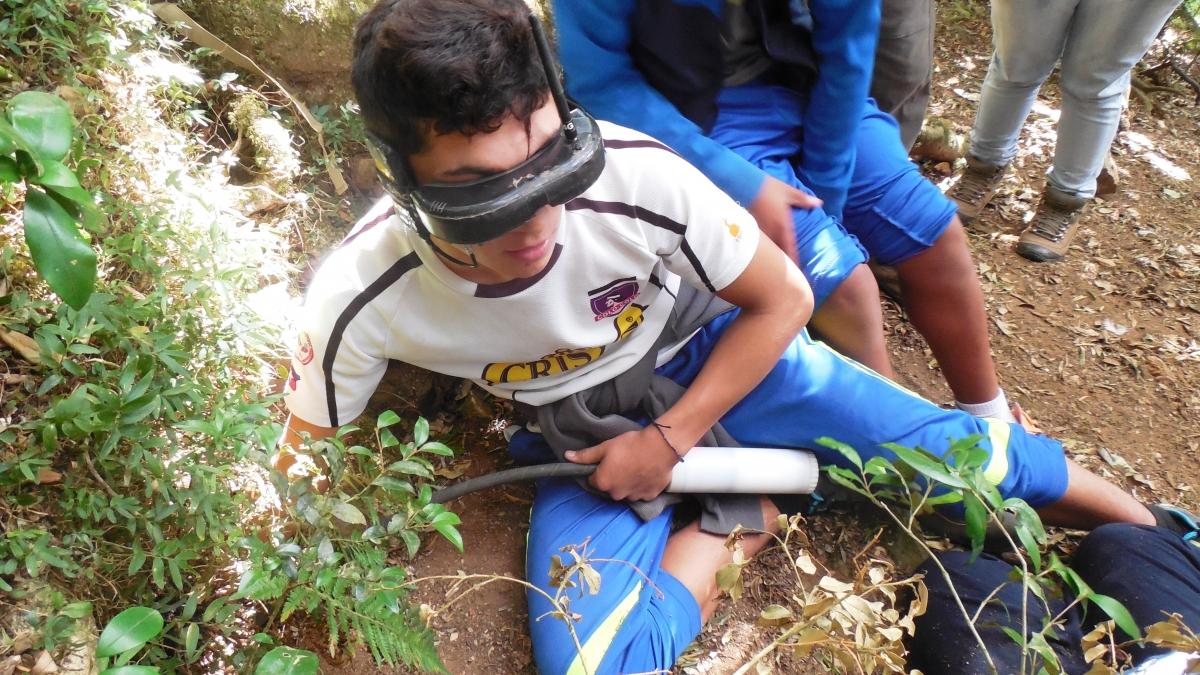 Mochan middle-schooler Matias Aguirre checking a Pink-footed Shearwater chick with a specially-designed infra-red burrow camera. 
